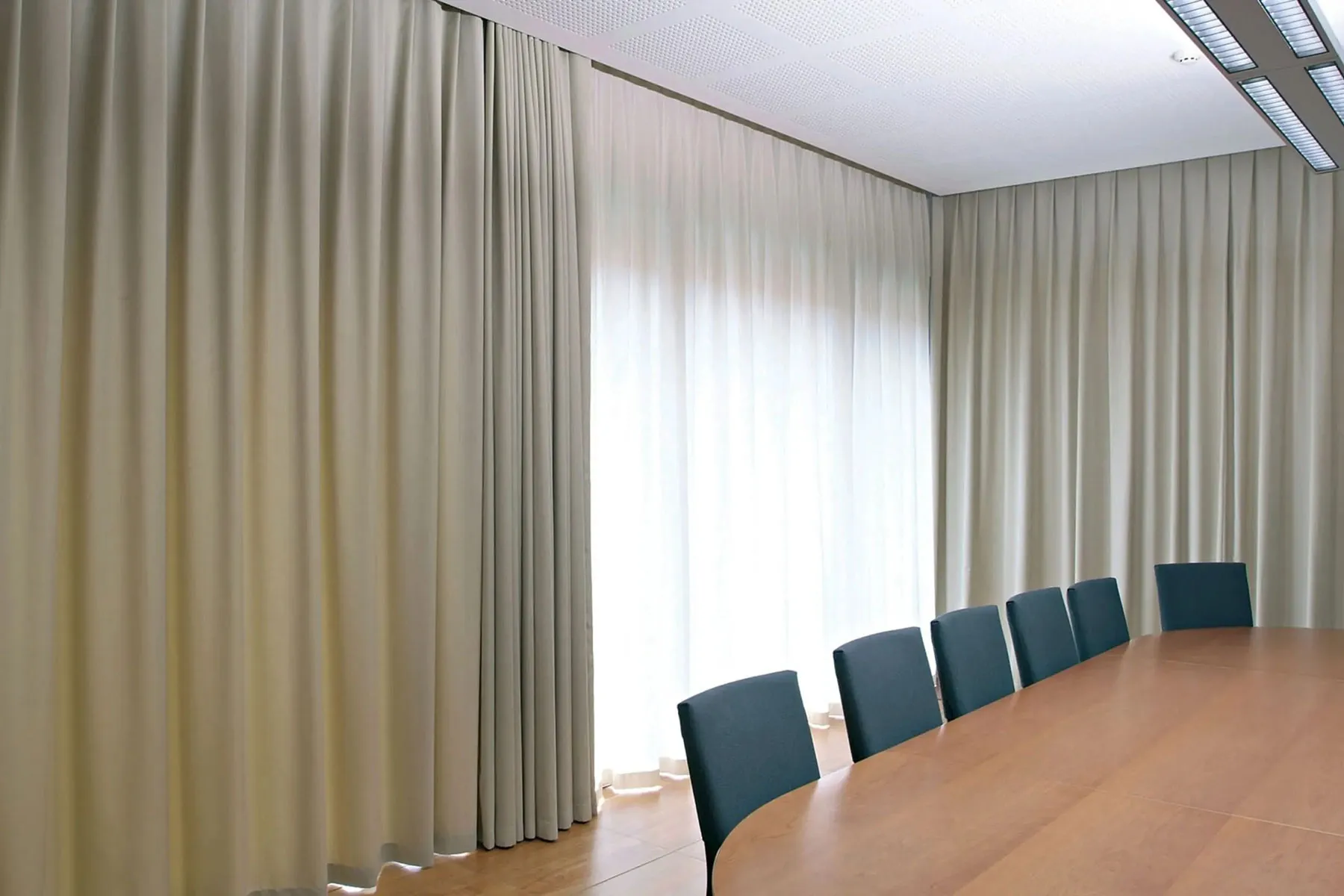 Tende a scorrimento Mottura aperte solo parzialmente per schermare la parte illuminata di un vetro della sala riunioni
